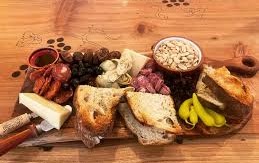 A board of sandwiches, cheese, vegetables, and small bites